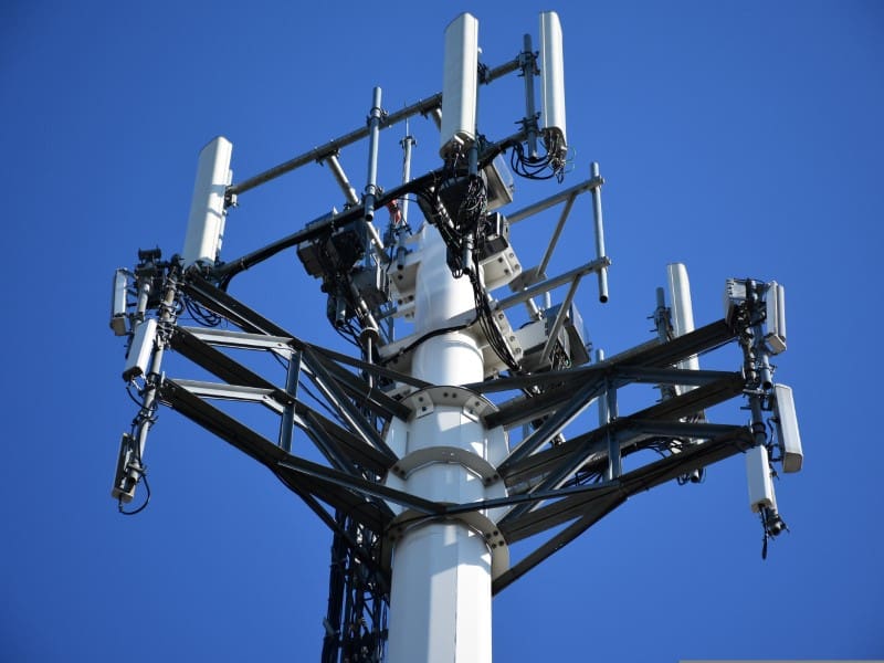 A cell phone tower with many antennas on it.