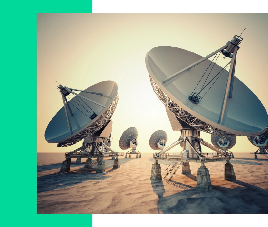 A group of satellite dishes sitting on top of a sandy beach.