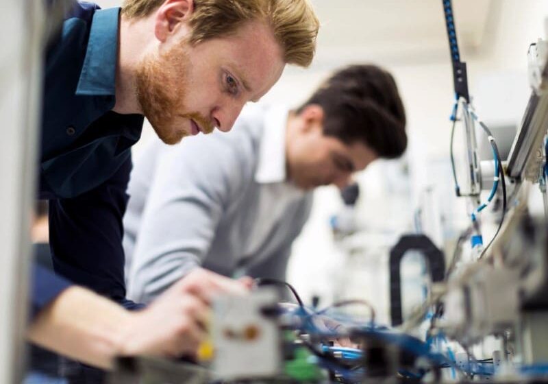 Two men working on electronics in a lab.